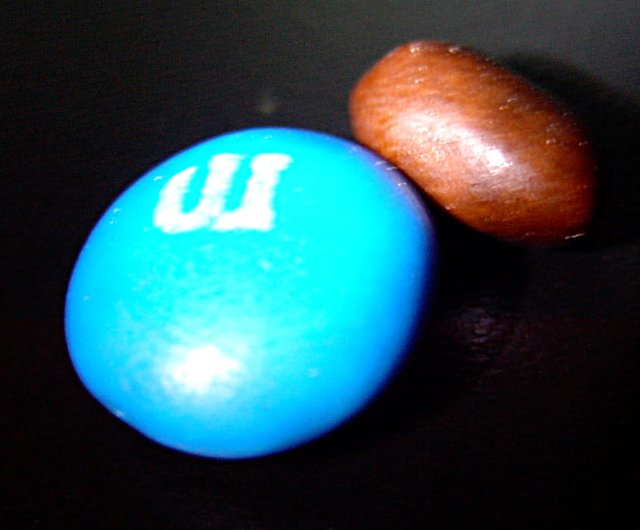 You know how at the very bottom of a bag of potato chips, you are left with downright useless kibble? That effect is apparently also present with M&M's. Shown near a normal M&M for comparison, the last one in the package was very unimpressive.