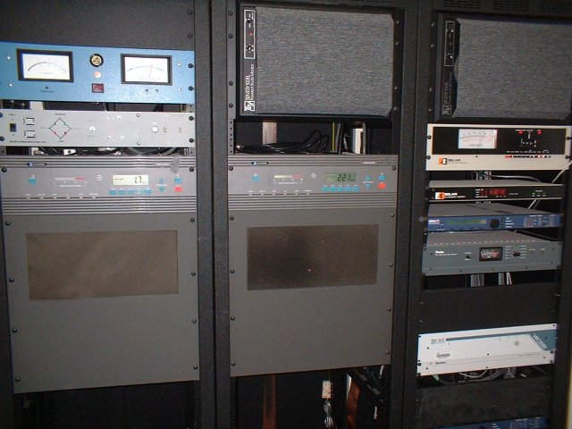 WRGP transmitter setup. Left: SWR meter/alarm, coax switch remote, Harris Quest 500 transmitter. Center: Electro-Voice rackmount speaker, Harris Quest 500 transmitter (backup). Right: Speaker, Belar FMM-2 modulation meter, Belar frequency monitor, Orban Optimod-FM audio processor, Moseley STL reciever (currently not in use), rack blank, Berk remote unit (with Creepy Voice option!)